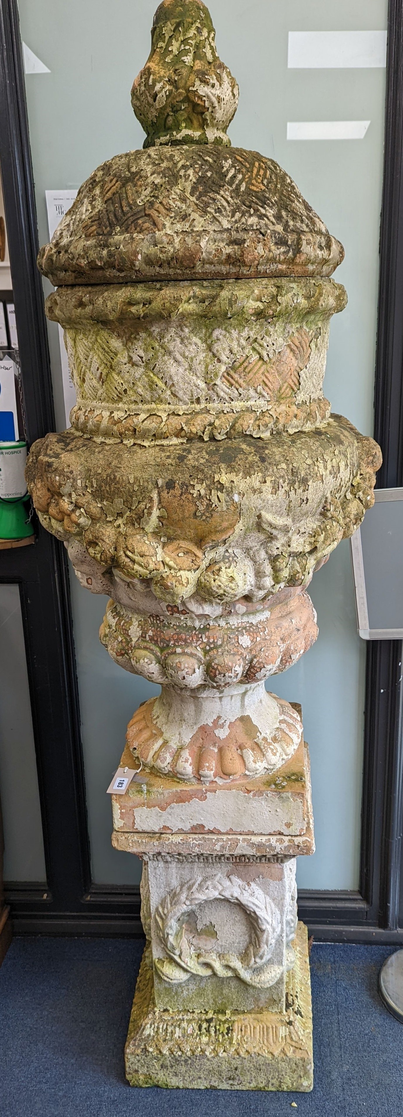 A large weathered Victorian painted terracotta lidded urn on plinth base, diameter 64cm, height 200cm